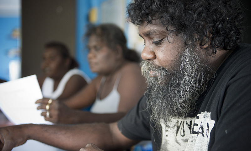 Middle aged Indigenous man looking at paper